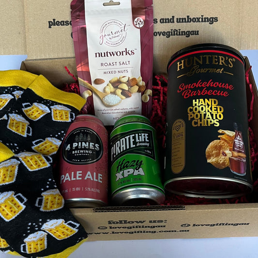 Gift box with snacks, beer, and a mug with text and product branding.