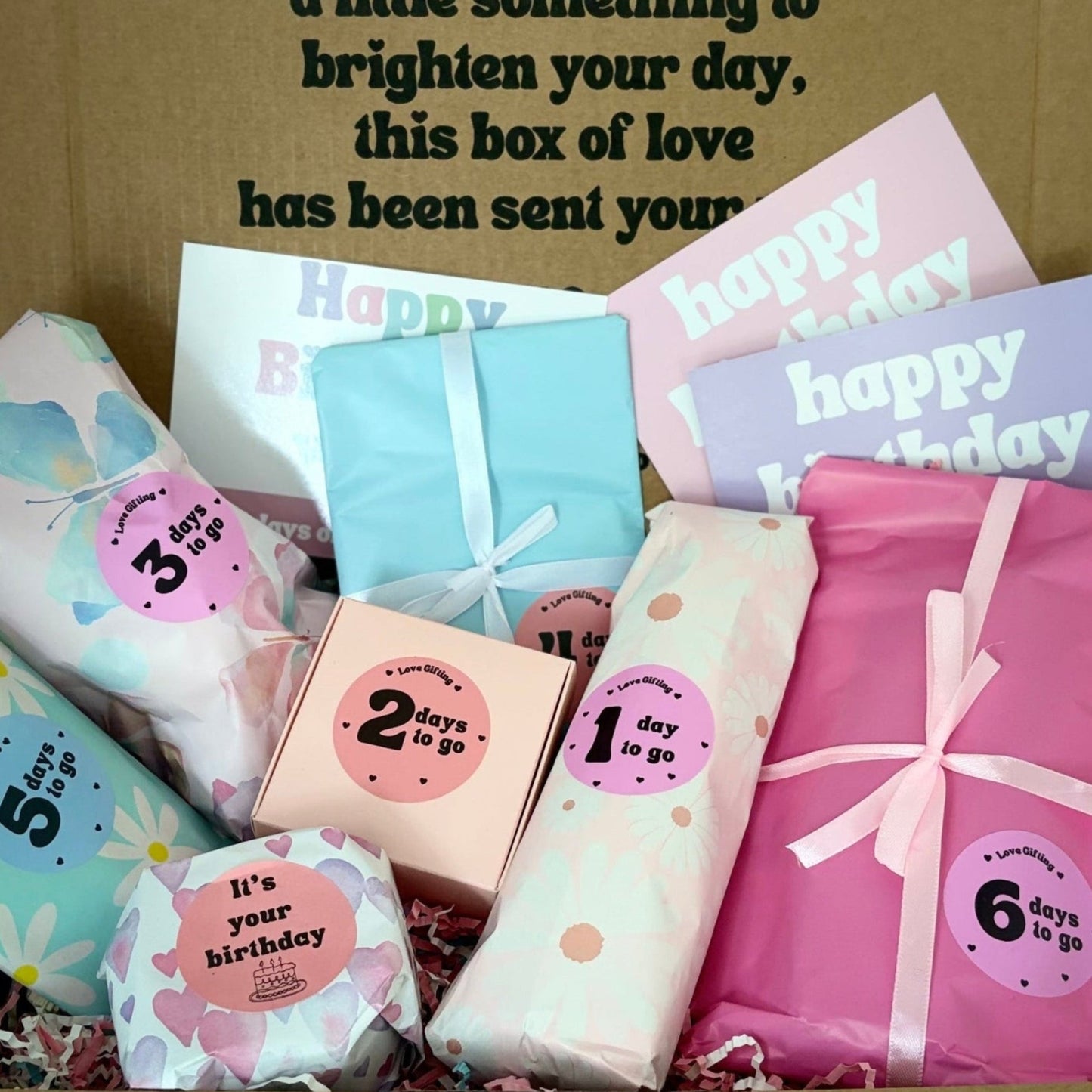 Box of assorted colorful greeting cards with 'Happy Birthday' text on a plain background