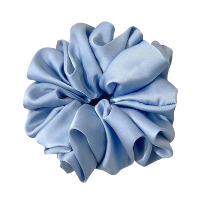 Gift box with self-care items including a sleep mask, bath bombs, and pouches on a wooden surface.