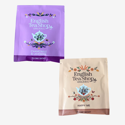 Two English Tea Shop tea bags, one purple and one beige, on a white background.