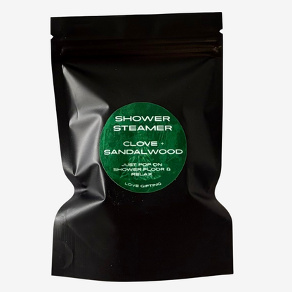 Love Gifting Clove and Sandalwood Shower Steamers in black packaging with green label, refreshing aromatic shower treats for self-care and gifting.