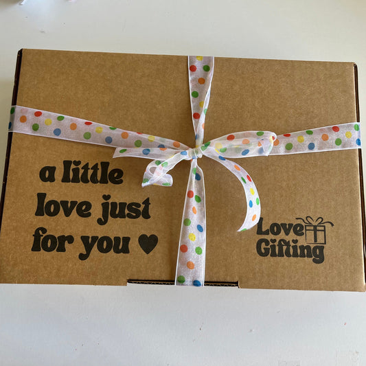 Brown gift box with a polka dot ribbon and 'Love Gifting' text on a white background