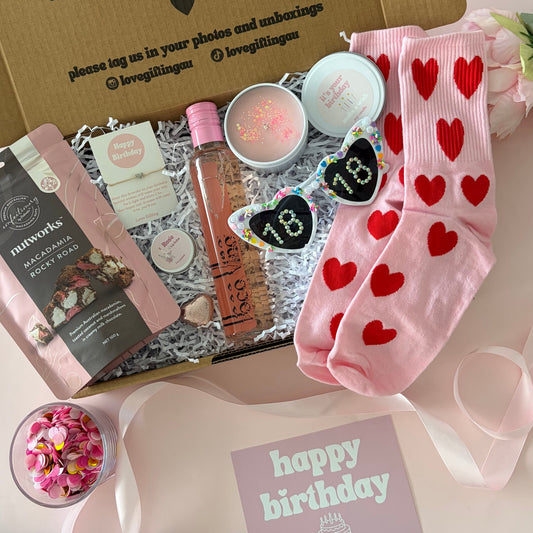 18th gift box including rocky road, rose wine, fun glasses, socks, bracelet , candle and lipbalm