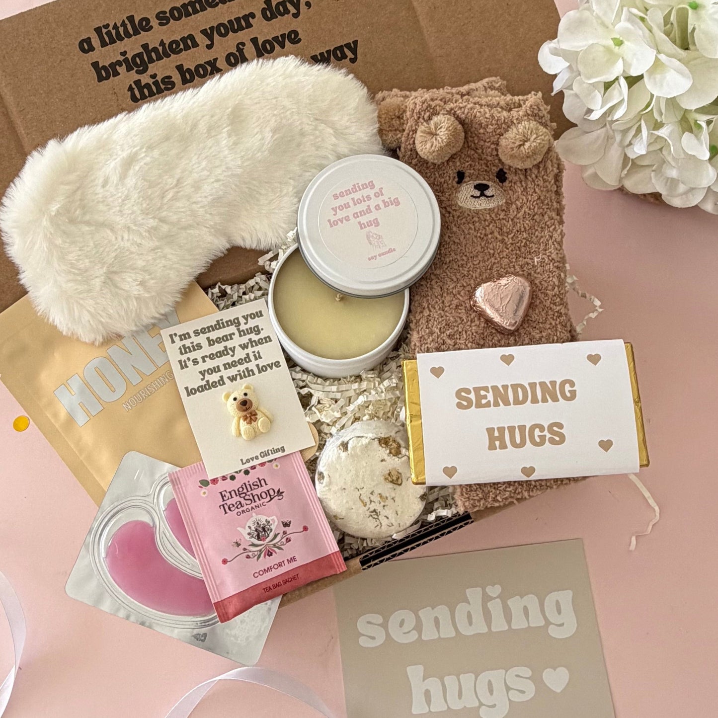 Sending Hugs Gift Box including candle, bear socks, lapcos facemask sheet, teabag, under eye, choc heart. shower steamer and Sending Hugs Chocolate