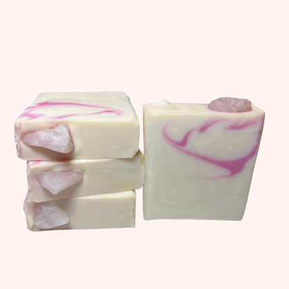Three bars of soap with pink and white swirls on a white background