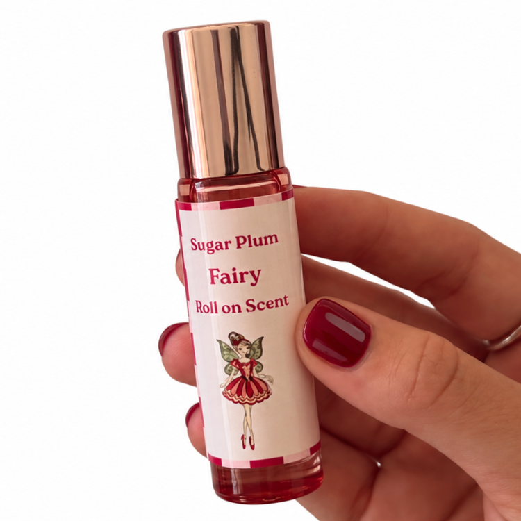 Sugar Plum Fairy Roll-On Scent with festive fairy label, held in hand with burgundy nails – Christmas gift Australia