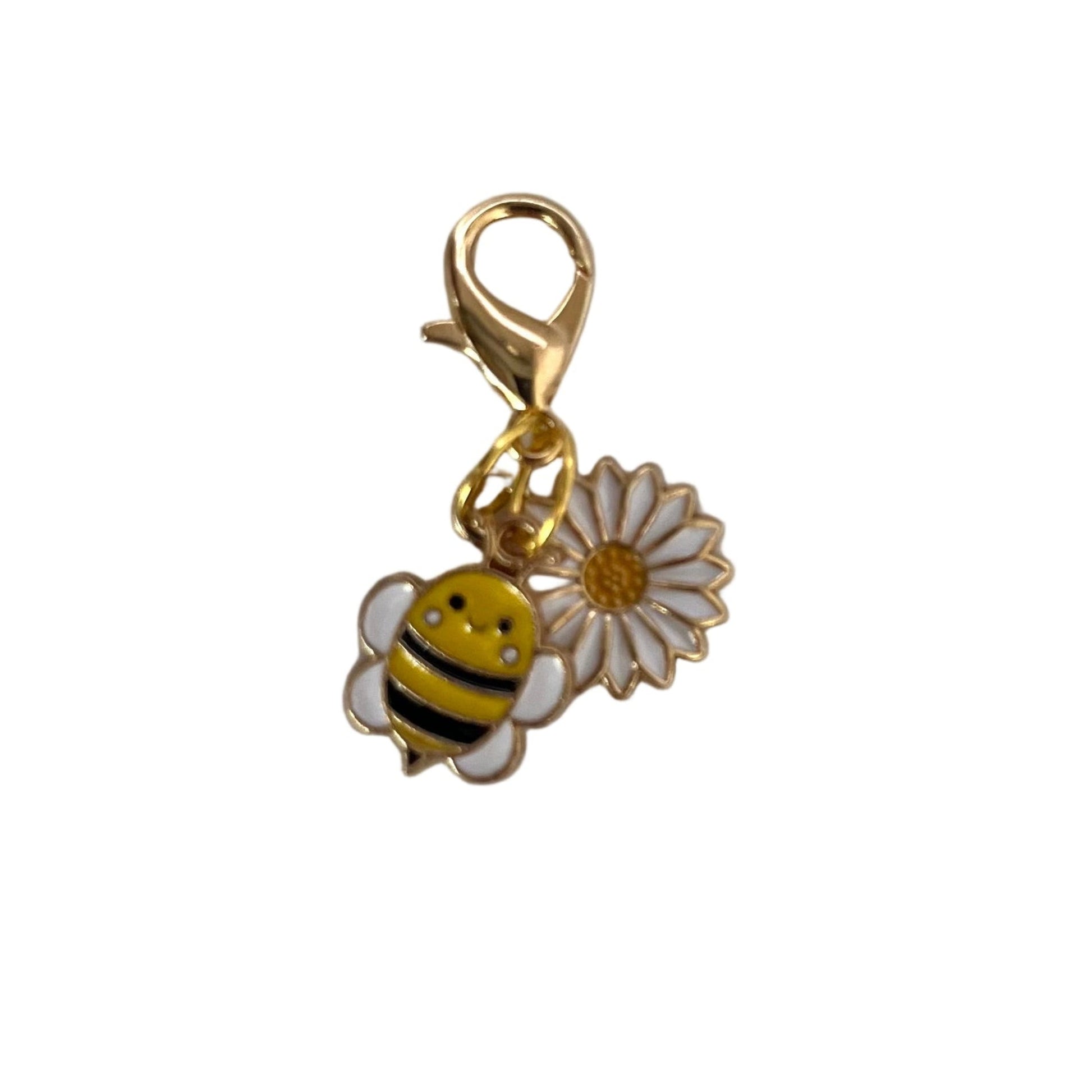 Gold charm with a bee and flower on a white background