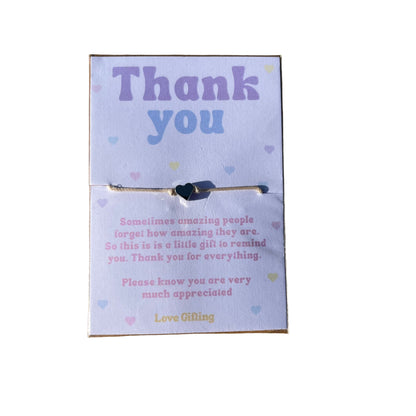 Card with 'Thank you' text on a textured brown surface