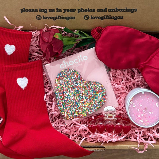 Valentine's Day Gift box with red socks, a heart-shaped chocolate , sleep mask , candle and rose 