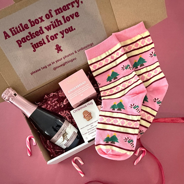 Christmas gift box with sparkling rosé, Chocilo gingerbread chocolates, festive socks and a Christmas Pocket Hug. Shop Love Gifting.