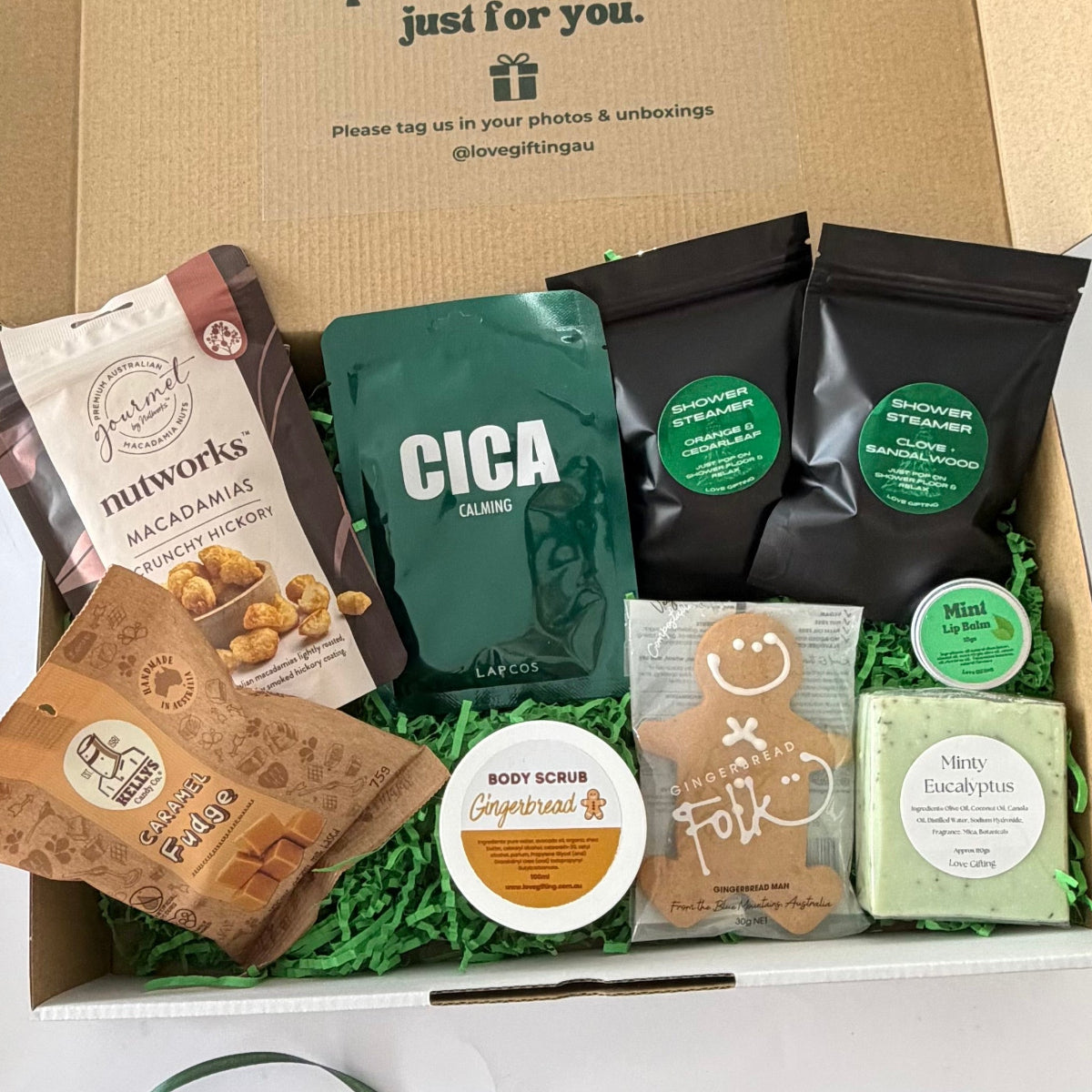 Merry & Minty Men's Christmas Gift Box featuring gingerbread, caramel fudge, macadamias, shower steamers, mint lip balm, eucalyptus soap and pamper treats in festive gift packaging.