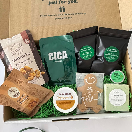 Merry & Minty Men's Christmas Gift Box featuring gingerbread, caramel fudge, macadamias, shower steamers, mint lip balm, eucalyptus soap and pamper treats in festive gift packaging.