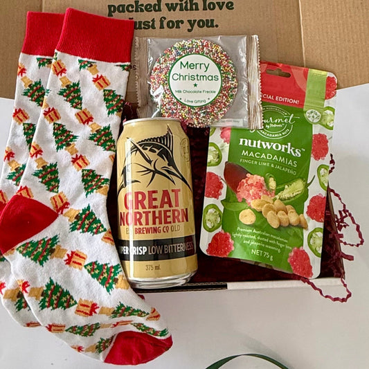 Christmas Cheers & Crunch beer gift box featuring Great Northern Super Crisp beer, Nutworks finger lime and jalapeño macadamias, festive Christmas socks and milk chocolate freckle.