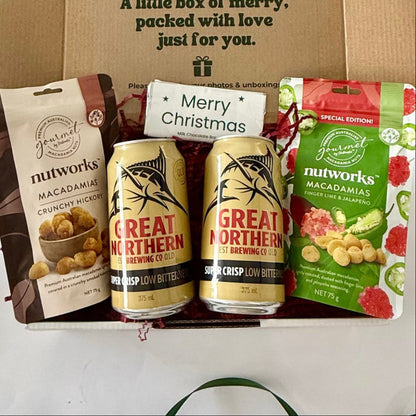 Christmas Cheers Beers & Nibbles men's gift box featuring two Great Northern Super Crisp beers, Nutworks hickory and finger lime jalapeño macadamias and Merry Christmas milk chocolate.