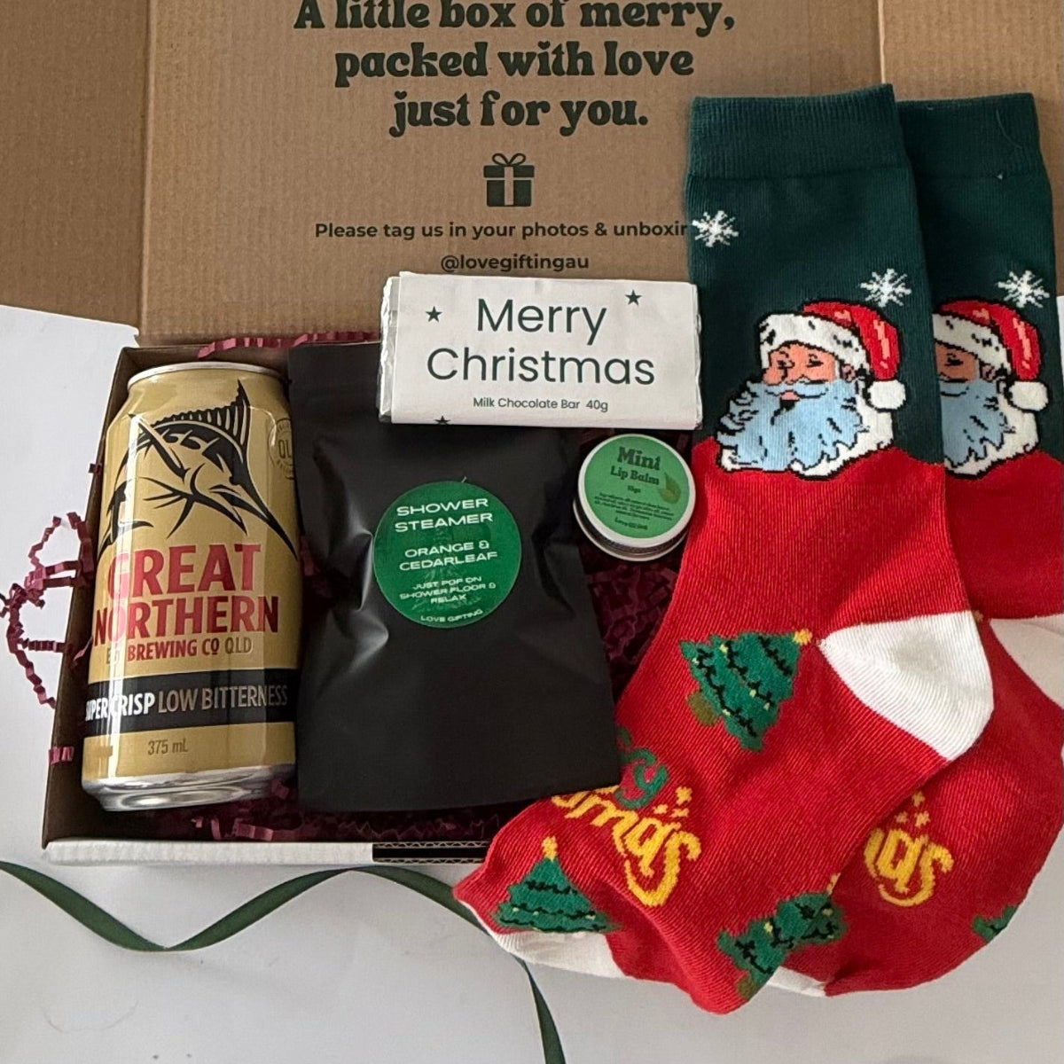 Treat him to Santa's Night Off! A men's Christmas gift box with beer, Santa socks, shower steamer, mint lip balm and a choice of festive sweet treat.