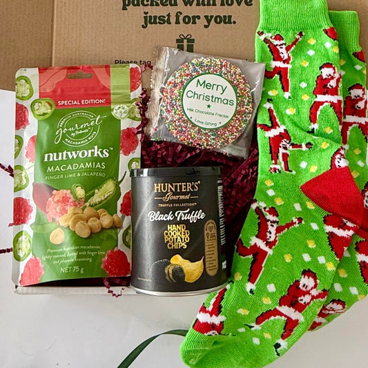 Santa's Snack Attack men's Christmas gift box with Nutworks finger lime and jalapeño macadamias, black truffle chips, chocolate freckle and green Santa socks.
