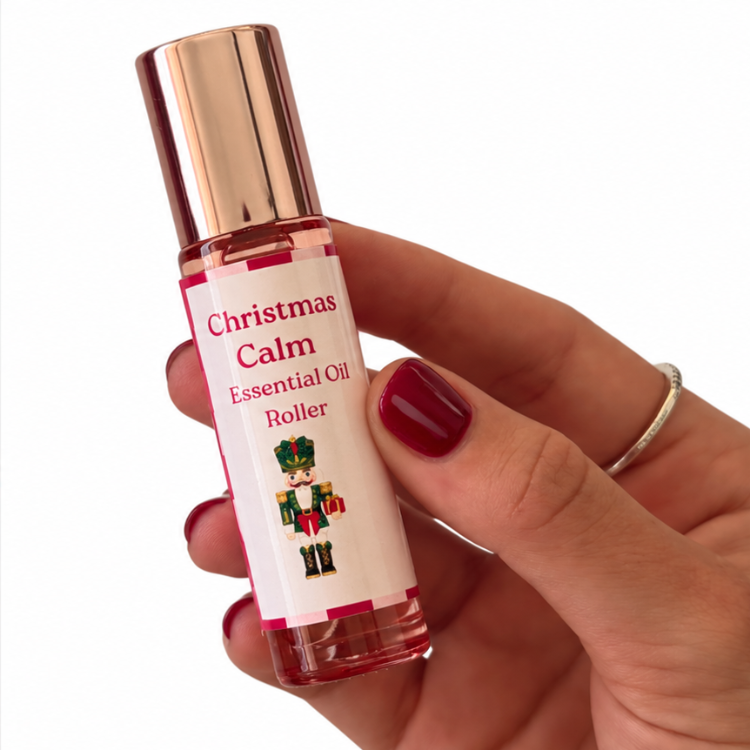 Christmas Calm Essential Oil Roller with festive nutcracker label, held in hand with burgundy nails – Christmas gift box add-on