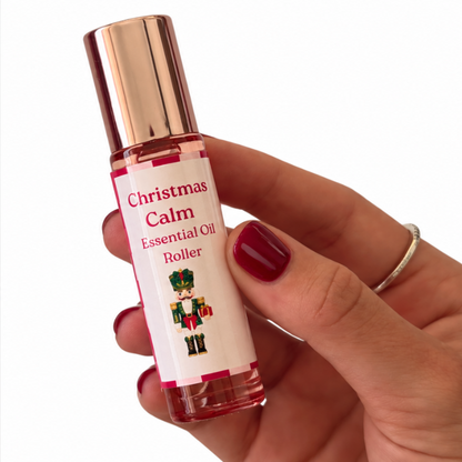 Christmas Calm Essential Oil Roller with festive nutcracker label, held in hand with burgundy nails – Christmas gift box add-on